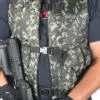Camouflage vest with black straps and gun.