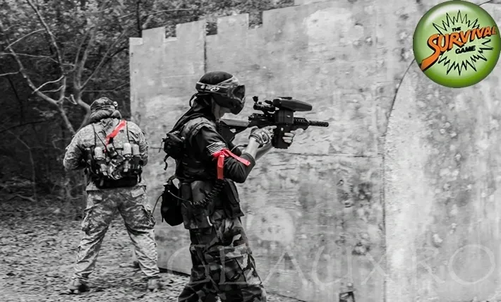 Two men in camouflage gear are playing a game of paintball.