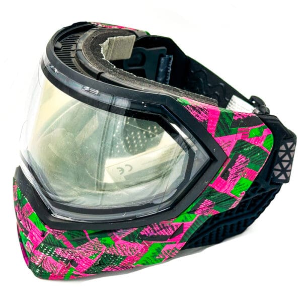 Pink and green paintball goggle with clear lens.