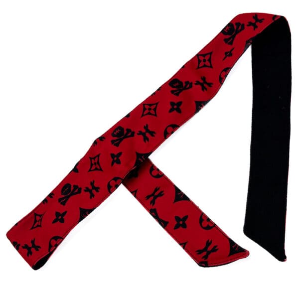 Red bandana with black skull and flower pattern.