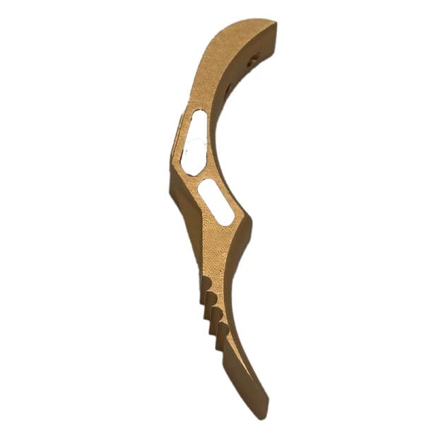 Gold-colored firearm trigger upgrade.