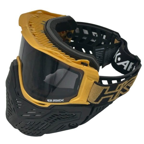 Gold and black motocross goggles with strap.